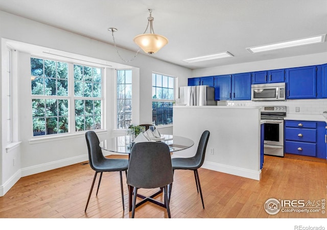 dining room with light wood-type flooring and baseboards