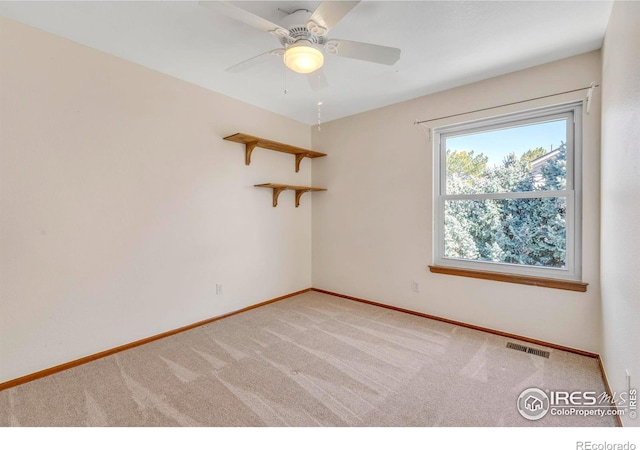 unfurnished room with visible vents, light carpet, baseboards, and ceiling fan