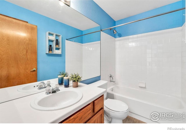 bathroom with toilet, vanity, and  shower combination