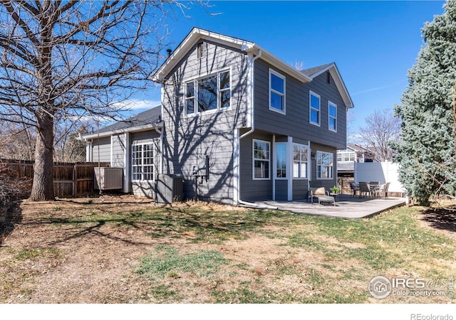 rear view of property with fence, a lawn, and a patio area