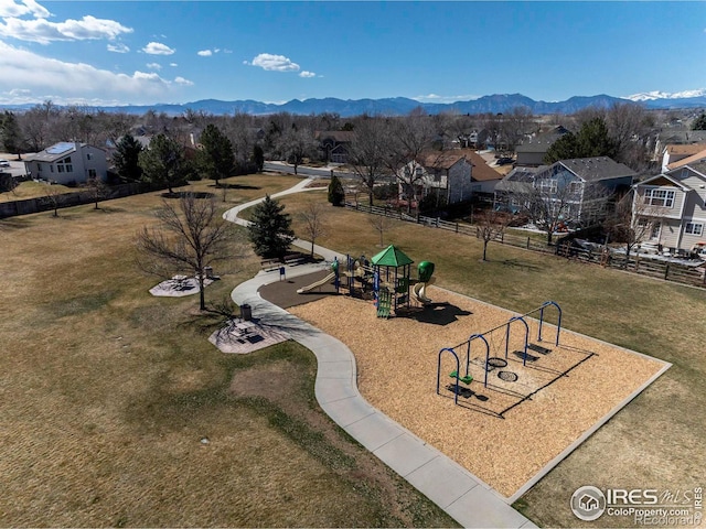 communal playground with a mountain view, a residential view, a lawn, and fence