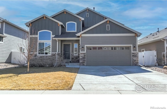 view of front facade featuring stone siding, board and batten siding, and concrete driveway