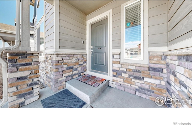 doorway to property with stone siding