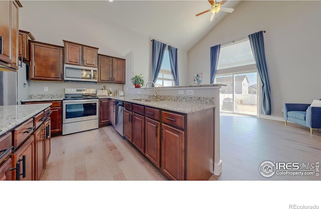 kitchen with a wealth of natural light, appliances with stainless steel finishes, ceiling fan, and a sink