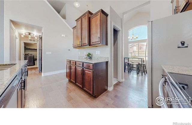 kitchen with light wood-type flooring, light stone countertops, high vaulted ceiling, and dishwasher