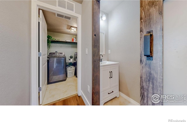 bathroom with visible vents, baseboards, independent washer and dryer, and vanity