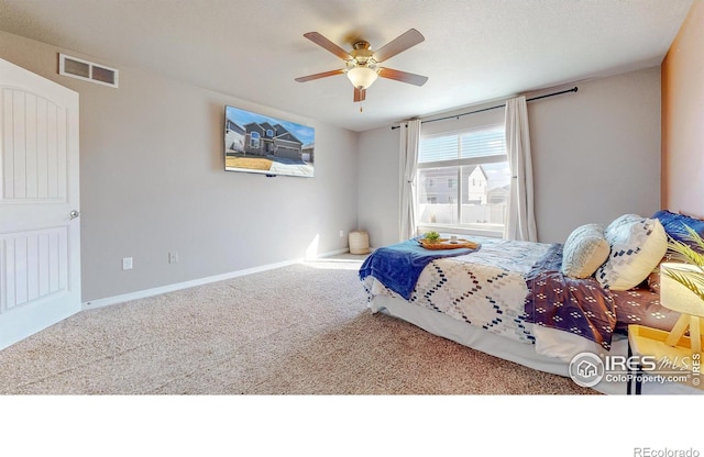 carpeted bedroom featuring baseboards, visible vents, and ceiling fan