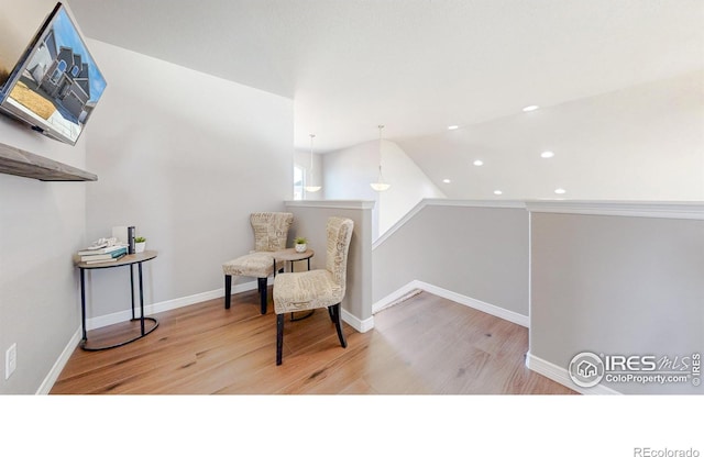 living area featuring wood finished floors, baseboards, lofted ceiling, recessed lighting, and an upstairs landing