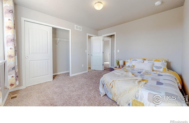 carpeted bedroom with visible vents, baseboards, and a closet