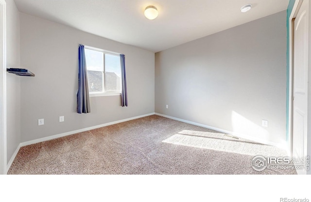 unfurnished room featuring carpet flooring and baseboards