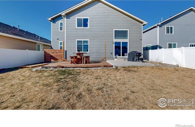 back of house featuring a yard and a fenced backyard