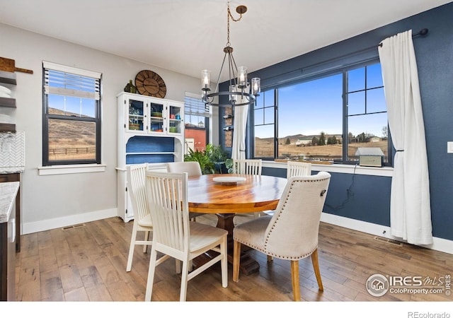 4528 Del Colina Way, Laporte, CO 80535 - dining space featuring a chandelier, hardwood / wood-style flooring, and baseboards