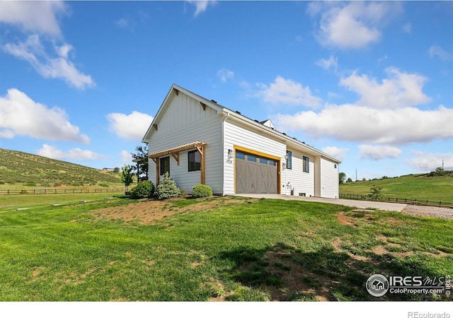 4528 Del Colina Way, Laporte, CO 80535 - view of home's exterior with board and batten siding, an attached garage, and a rural view