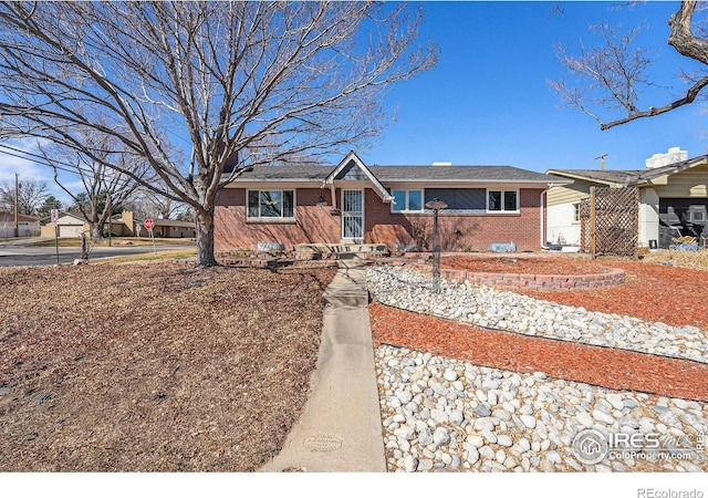 single story home featuring brick siding