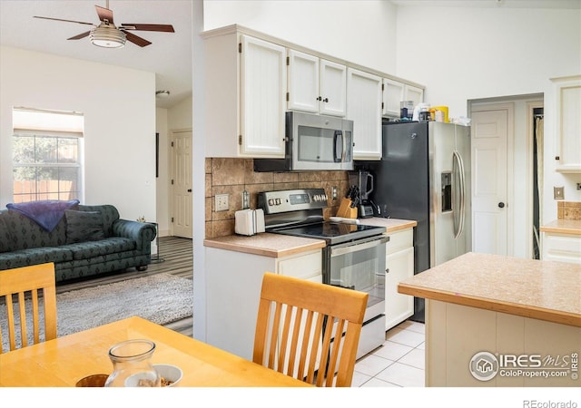 kitchen with stainless steel appliances, tasteful backsplash, ceiling fan, and light countertops