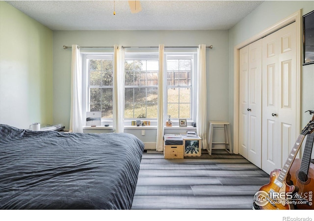 bedroom featuring a closet, multiple windows, and a textured ceiling