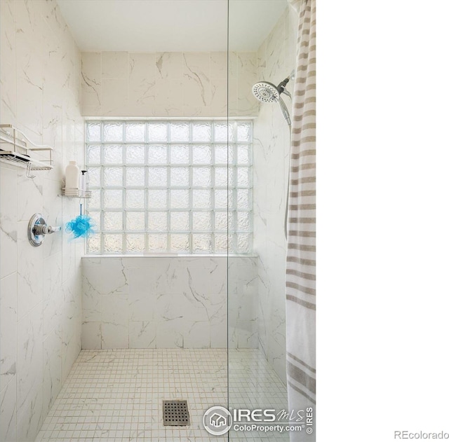 bathroom featuring a marble finish shower