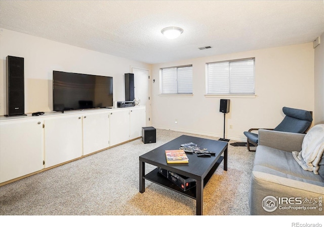 living area featuring light colored carpet, baseboards, and a textured ceiling