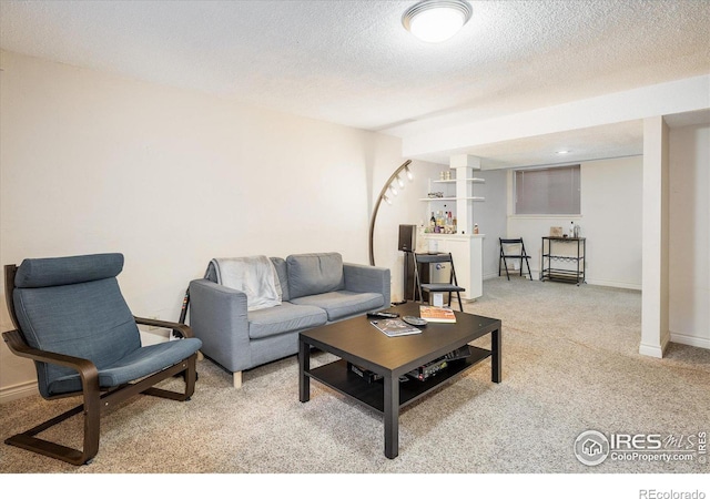 carpeted living area with baseboards and a textured ceiling