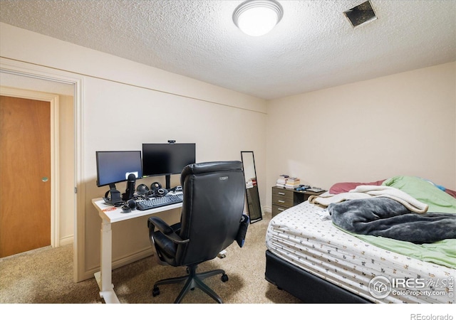 bedroom with visible vents, light colored carpet, and a textured ceiling