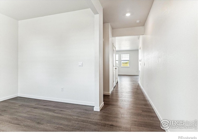 hall with baseboards and dark wood-style floors