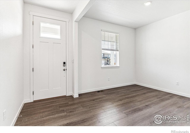 entryway with dark wood-type flooring and baseboards