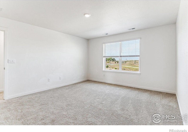 spare room with baseboards, visible vents, and carpet floors