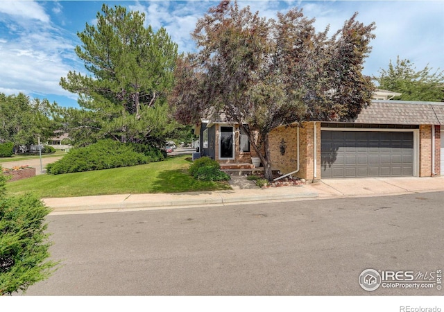 obstructed view of property featuring brick siding, an attached garage, driveway, and a front lawn