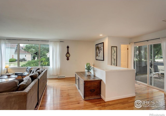 living room with visible vents, recessed lighting, baseboards, and light wood-style floors