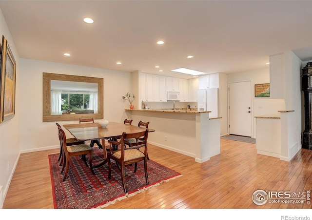 dining room featuring recessed lighting, light wood-type flooring, and baseboards