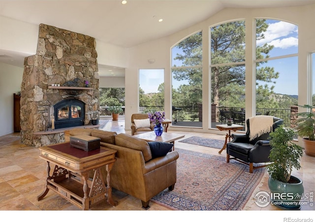 living room featuring recessed lighting, a fireplace, and high vaulted ceiling