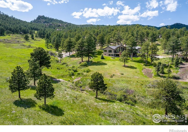 bird's eye view with a wooded view