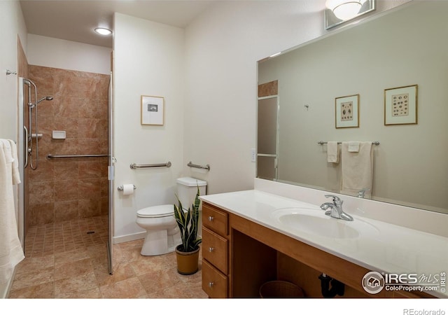 bathroom featuring tiled shower, toilet, and vanity