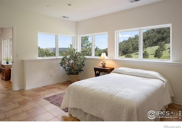 bedroom with light tile patterned floors, baseboards, and visible vents