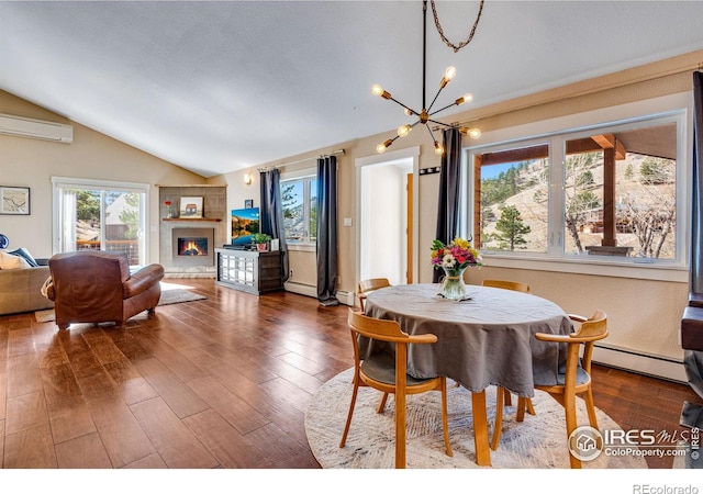 dining area featuring a tiled fireplace, vaulted ceiling, an inviting chandelier, wood finished floors, and a baseboard radiator