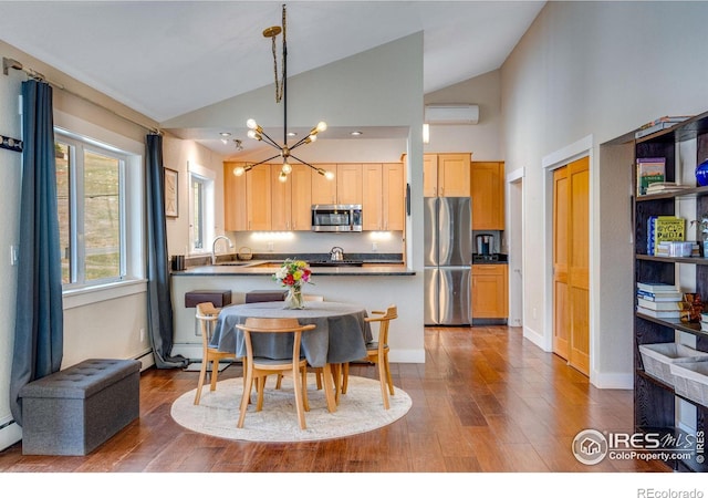 dining area featuring baseboards, high vaulted ceiling, an inviting chandelier, and wood finished floors