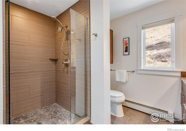 bathroom with a baseboard heating unit, toilet, and a stall shower