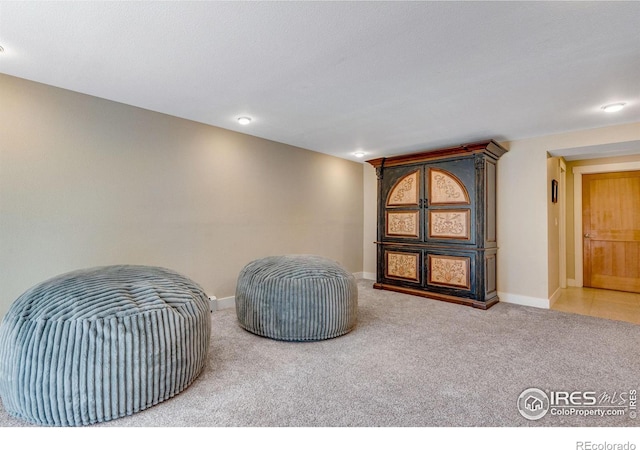 sitting room with baseboards and carpet floors