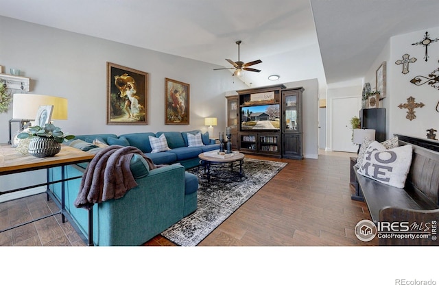 living area with wood finished floors, a ceiling fan, and vaulted ceiling