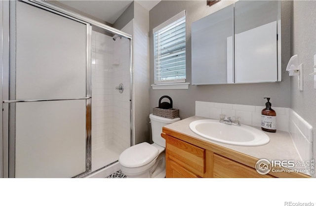 full bath with toilet, a stall shower, and vanity