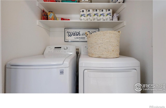 clothes washing area featuring separate washer and dryer and laundry area