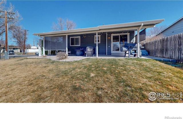 back of property featuring a patio area, a yard, and fence