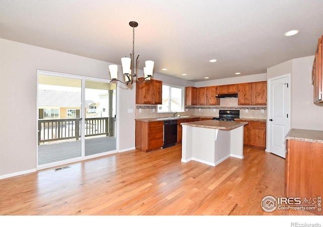 kitchen with visible vents, black appliances, light wood-style flooring, backsplash, and brown cabinetry