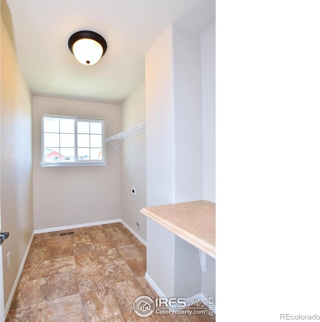 spacious closet with visible vents and stone finish floor