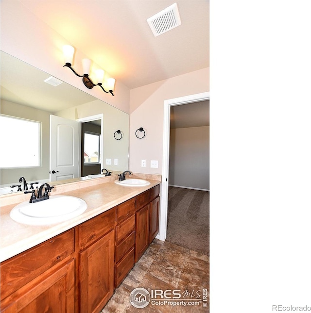 bathroom featuring double vanity, visible vents, and a sink