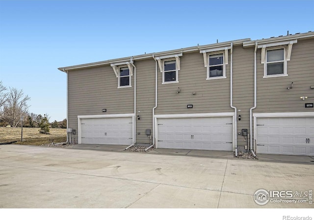 back of property featuring driveway and a garage