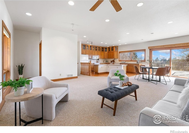 living room with a ceiling fan, recessed lighting, baseboards, and light carpet