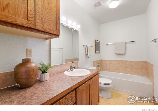 full bathroom with vanity, toilet, a bath, and visible vents