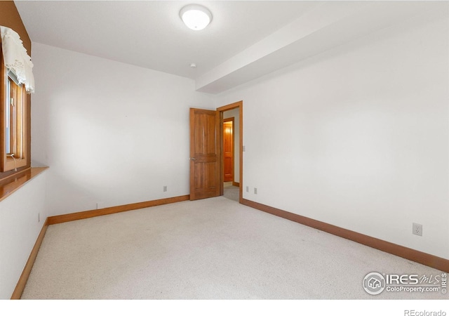 carpeted empty room with baseboards