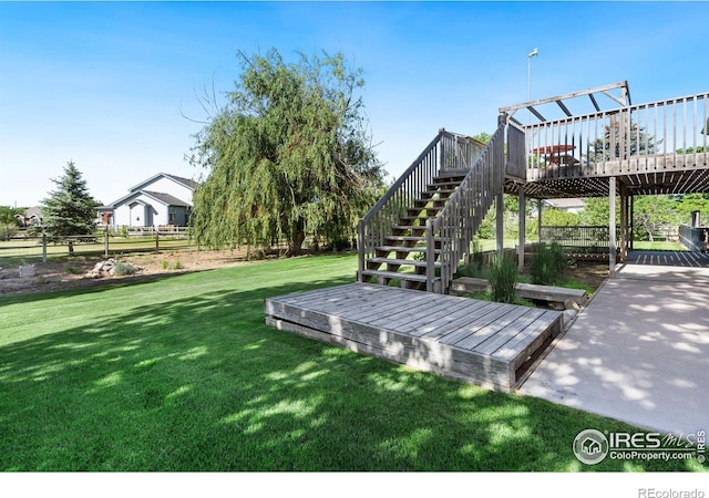 surrounding community with a yard, a deck, stairs, and fence